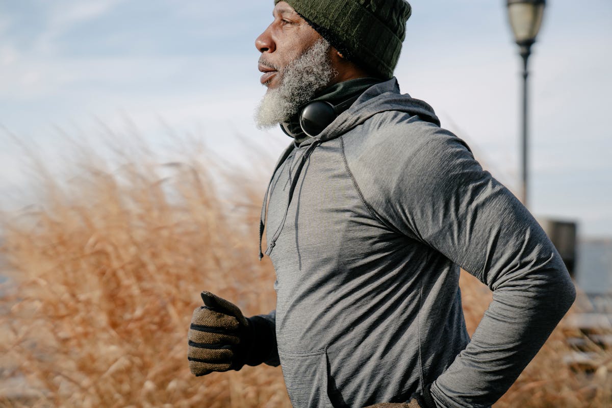 Man in a beanie on a run outside.