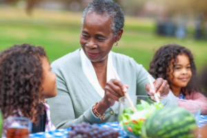 Older woman serving food to grandchildren